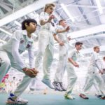 junior cricketers in whites train indoor, photo taken from floor angle looking up as they do jumps