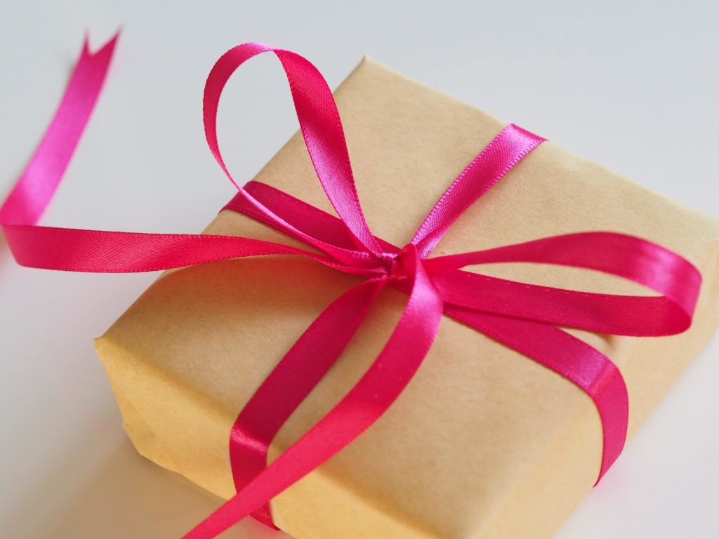 square present wrapped in brown paper with pink ribbon