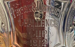 Close up of the metal trophy lettering of 'Thirsk & District Challenge Cup'
